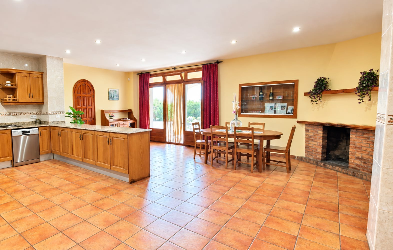 Vista completa de la amplia cocina con isla, mesa y chimenea