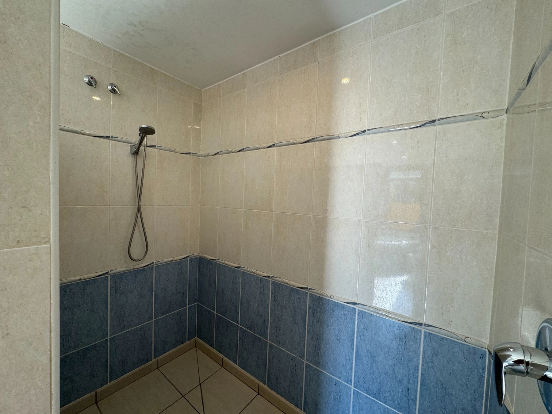 Zona de ducha con azulejos azules y claros