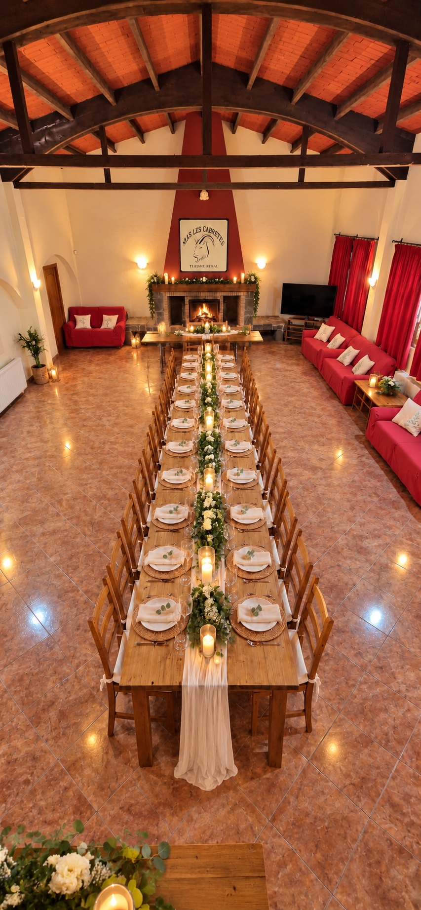 Comedor preparado para una celebración, con flores, velas y chimenea encendida